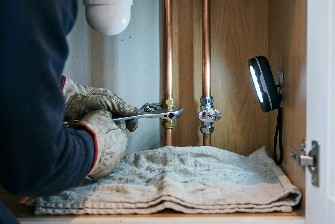 Tightening a compression fitting on copper pipe under a sink